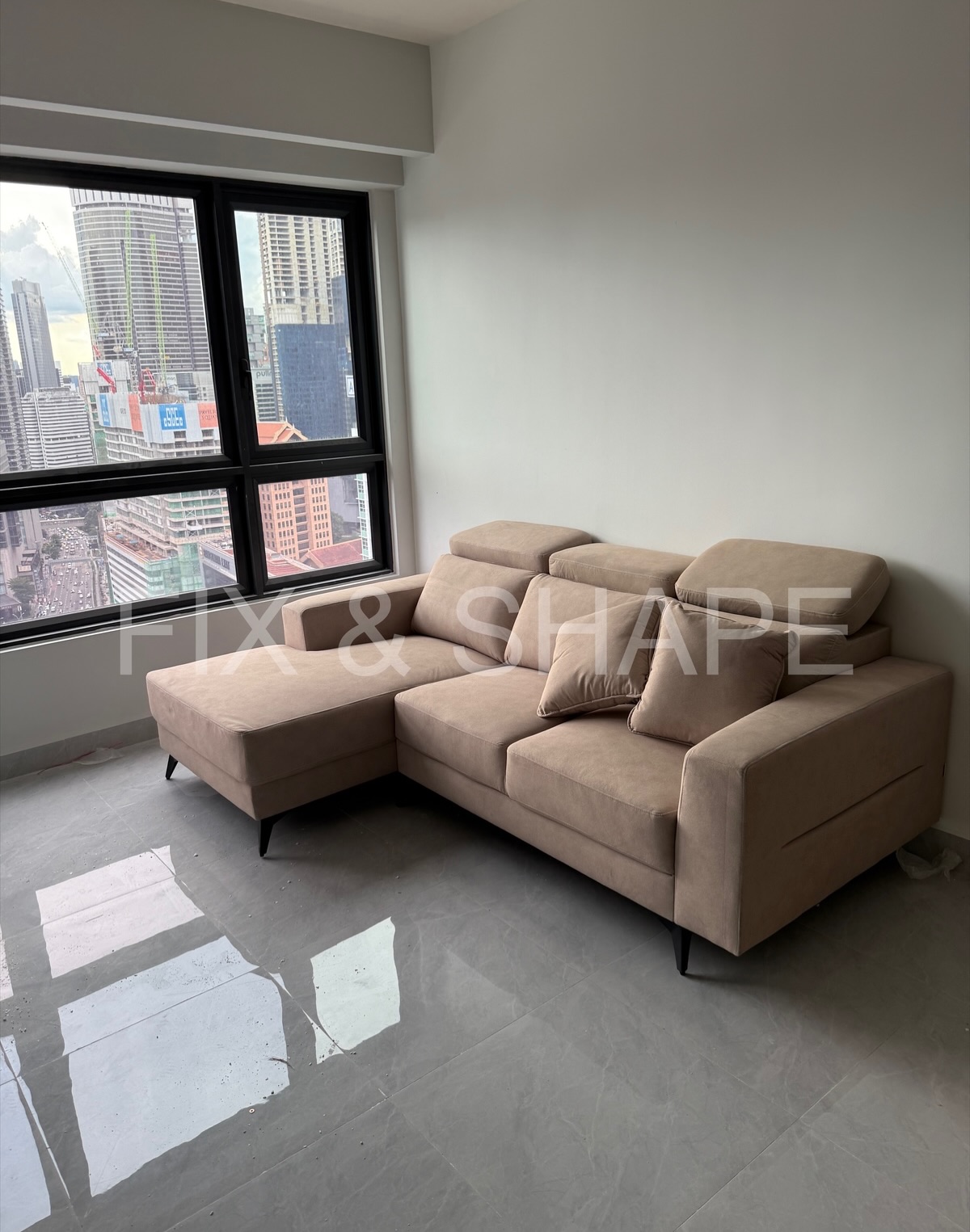 Living room furniture assembled by FIX & SHAPE in a Klang Valley high-rise, KL skyline beyond the window